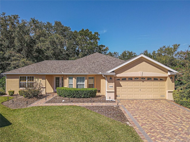 single story home featuring a garage and a front lawn