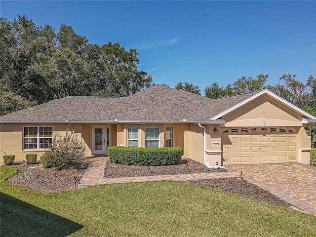 ranch-style house featuring a garage and a front lawn