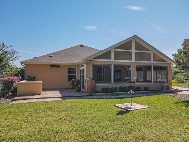 rear view of house with a yard, cooling unit, a patio, and a sunroom