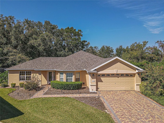 single story home featuring a front lawn and a garage