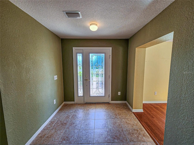 entrance foyer featuring a textured ceiling and light wood-type flooring