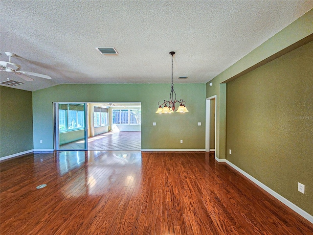 unfurnished dining area featuring ceiling fan with notable chandelier, a textured ceiling, lofted ceiling, and dark hardwood / wood-style floors