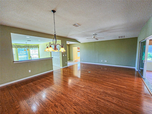 spare room featuring hardwood / wood-style flooring, a textured ceiling, and vaulted ceiling