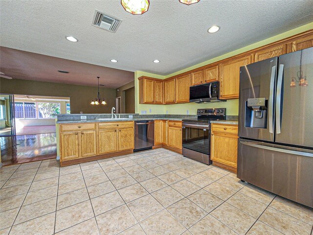 kitchen with light tile patterned flooring, appliances with stainless steel finishes, sink, and pendant lighting