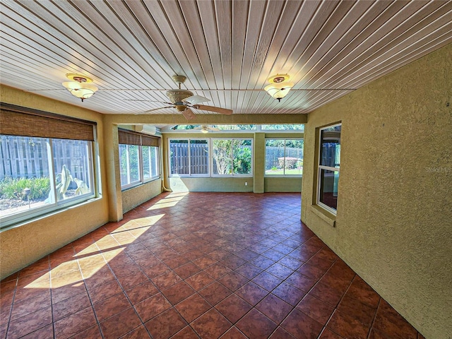 unfurnished sunroom with wood ceiling and ceiling fan