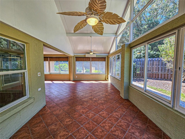 unfurnished sunroom with vaulted ceiling, ceiling fan, and plenty of natural light