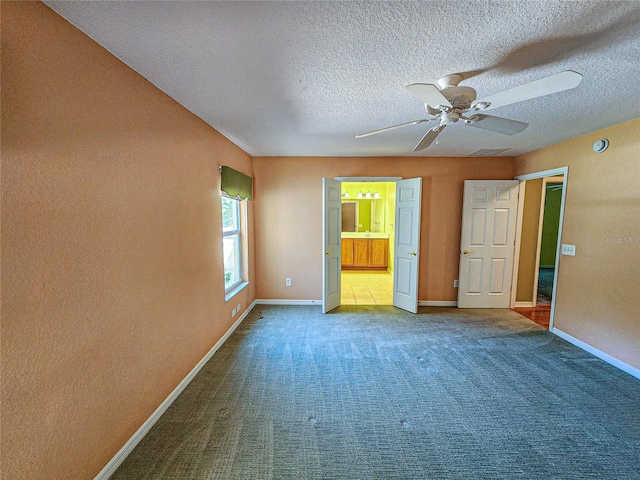 unfurnished bedroom with a textured ceiling, carpet flooring, and ceiling fan