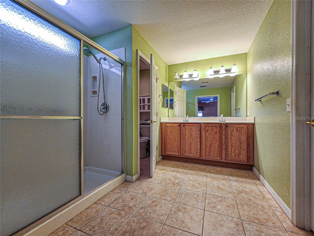 bathroom featuring vanity, a textured ceiling, toilet, and an enclosed shower