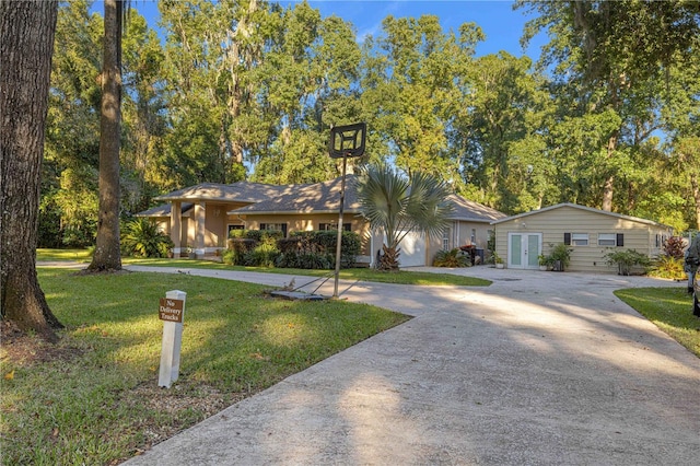 ranch-style house featuring french doors, driveway, and a front yard