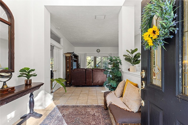 foyer entrance featuring light tile patterned flooring and a textured ceiling