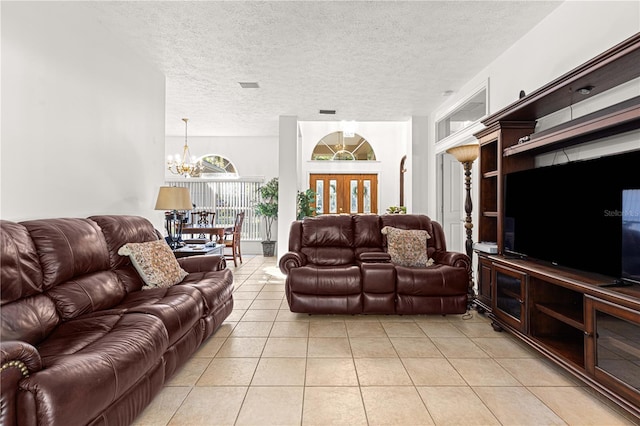 tiled living room featuring a chandelier and a textured ceiling