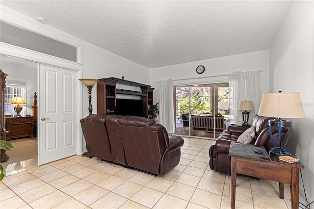 living room with a textured ceiling and light tile patterned floors