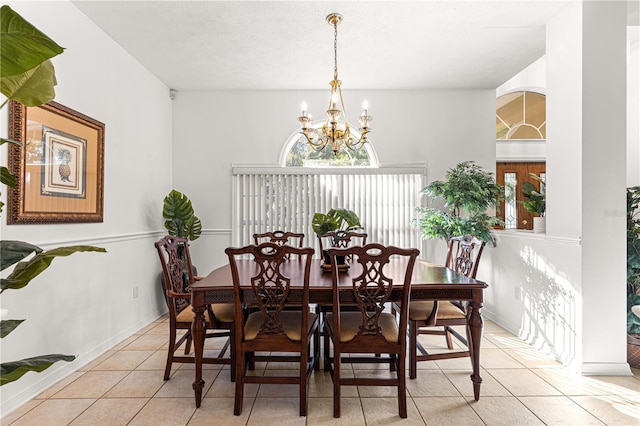 tiled dining area with a textured ceiling and a chandelier