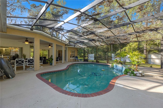 outdoor pool with ceiling fan, glass enclosure, and a patio