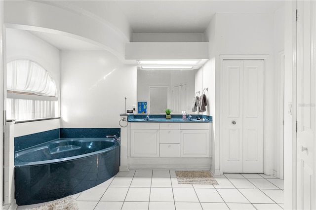 bathroom with a bath, vanity, and tile patterned floors