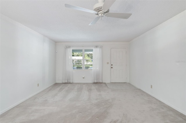 carpeted spare room with ceiling fan and a textured ceiling