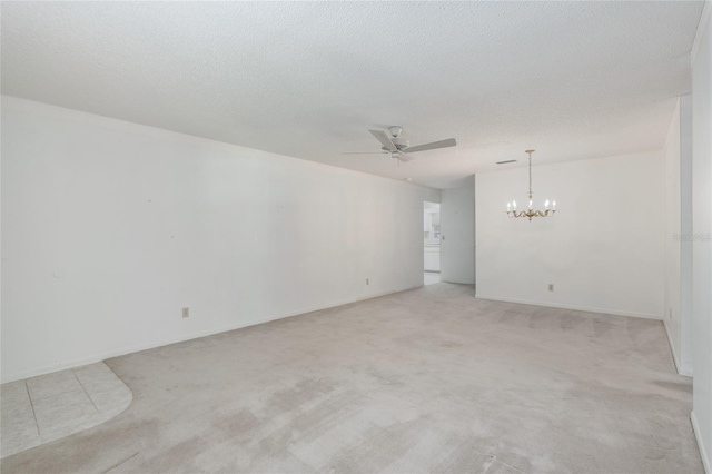 carpeted spare room with a textured ceiling and ceiling fan with notable chandelier