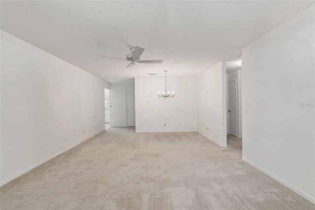 carpeted spare room with a textured ceiling and ceiling fan with notable chandelier