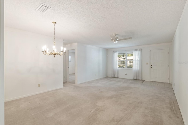 carpeted empty room featuring a textured ceiling and ceiling fan with notable chandelier