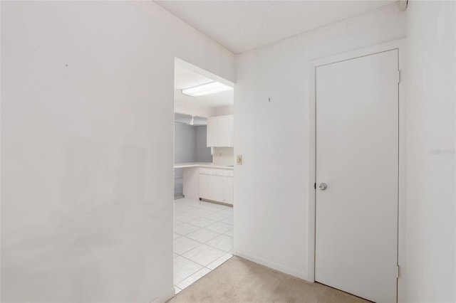 hallway featuring a textured ceiling and light tile patterned floors