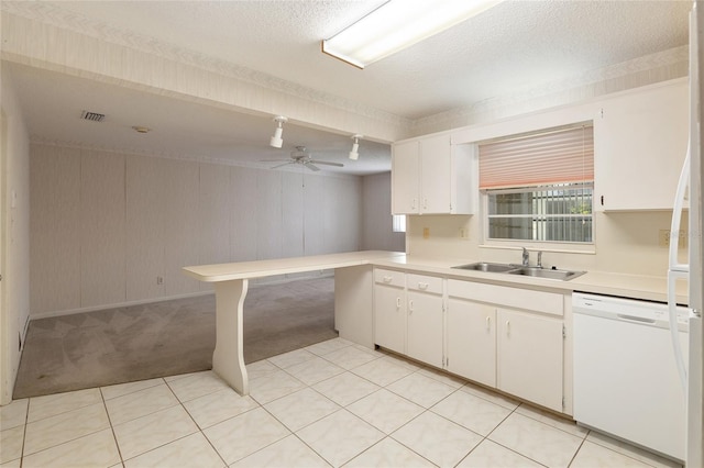 kitchen with white dishwasher, white cabinets, light carpet, and ceiling fan