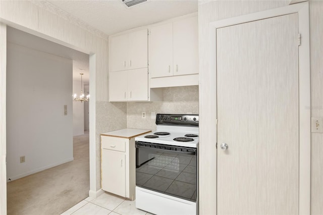 kitchen with a textured ceiling, white range with electric cooktop, white cabinetry, decorative backsplash, and light tile patterned floors