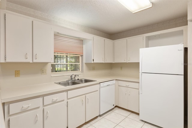 kitchen featuring white appliances, sink, light tile patterned flooring, a textured ceiling, and white cabinetry