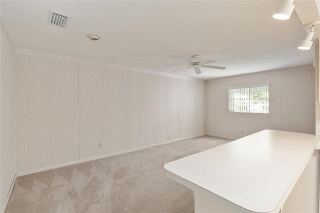 carpeted spare room with a textured ceiling and ceiling fan