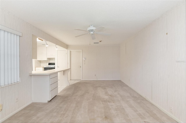 kitchen featuring tasteful backsplash, ceiling fan, white cabinetry, a textured ceiling, and white range with electric cooktop