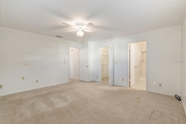 unfurnished room featuring light carpet, a textured ceiling, and ceiling fan