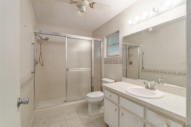 bathroom featuring toilet, tile patterned flooring, vanity, a textured ceiling, and an enclosed shower