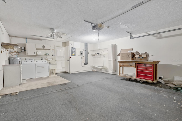 garage with electric panel, a garage door opener, washer and dryer, and ceiling fan