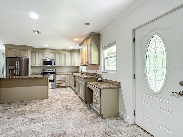 kitchen with dark stone countertops, stainless steel appliances, ornamental molding, and sink