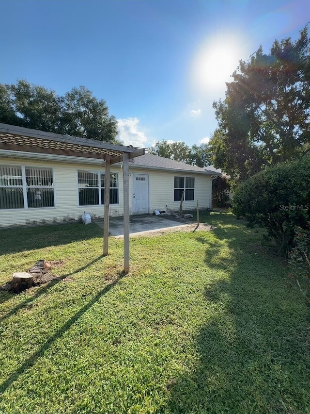 back of house with a patio and a lawn