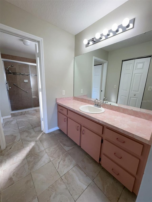 bathroom featuring vanity, a textured ceiling, and an enclosed shower