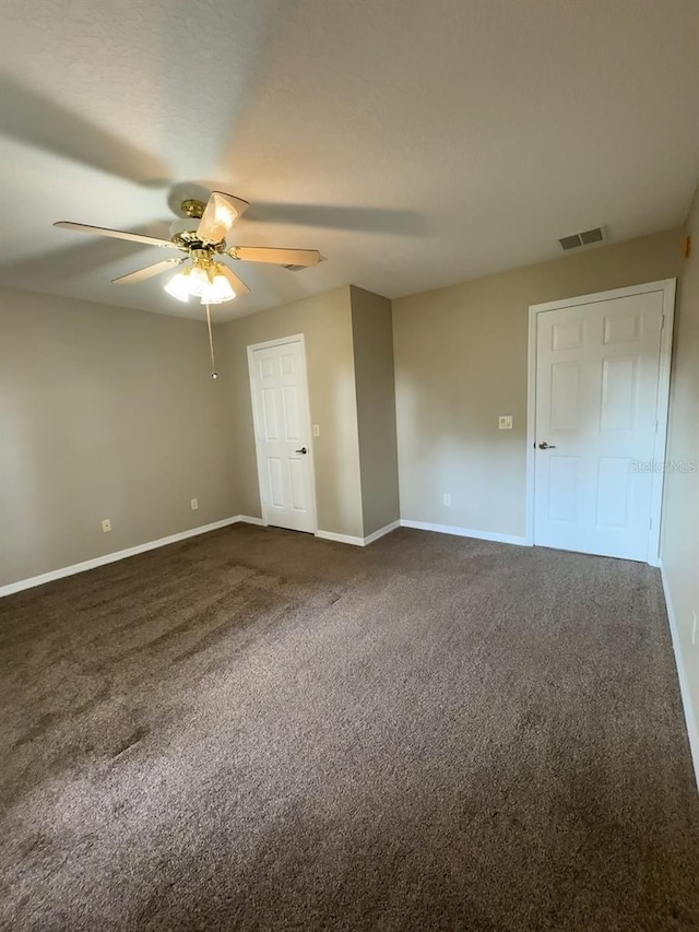 unfurnished bedroom featuring dark colored carpet and ceiling fan