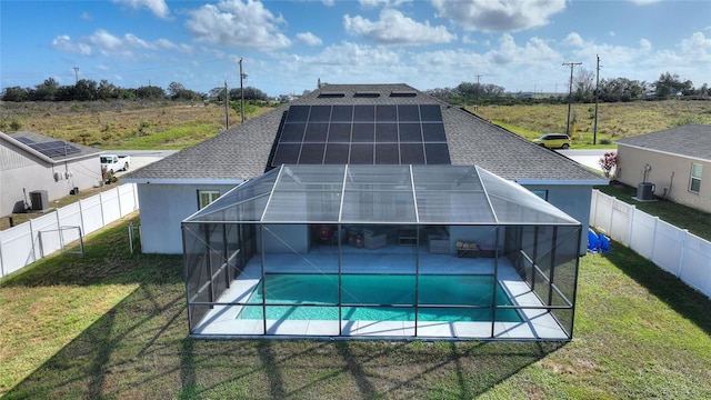 view of pool with a lawn and glass enclosure