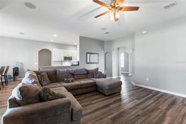 living room with sink, ceiling fan, and dark hardwood / wood-style flooring