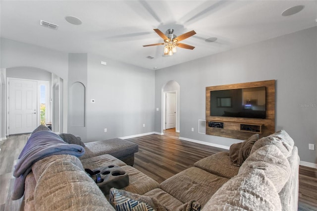 living room featuring ceiling fan and dark hardwood / wood-style floors