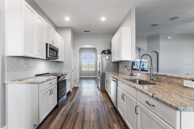 kitchen featuring light stone countertops, appliances with stainless steel finishes, sink, dark hardwood / wood-style flooring, and white cabinetry