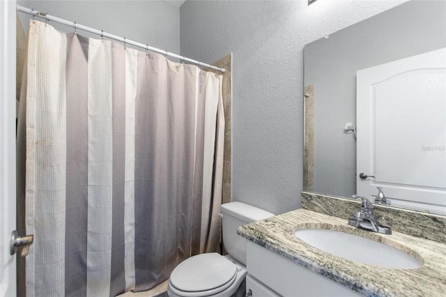 bathroom with vanity, curtained shower, and toilet