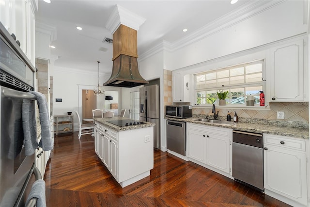 kitchen featuring a kitchen island, stainless steel appliances, sink, white cabinetry, and light stone counters