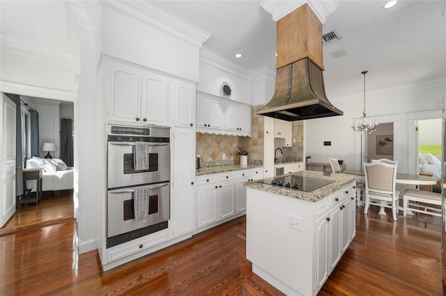 kitchen featuring a center island, black electric cooktop, stainless steel double oven, white cabinetry, and dark hardwood / wood-style floors