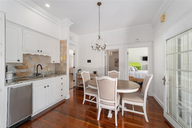 dining area with ornamental molding, sink, a notable chandelier, and dark hardwood / wood-style flooring