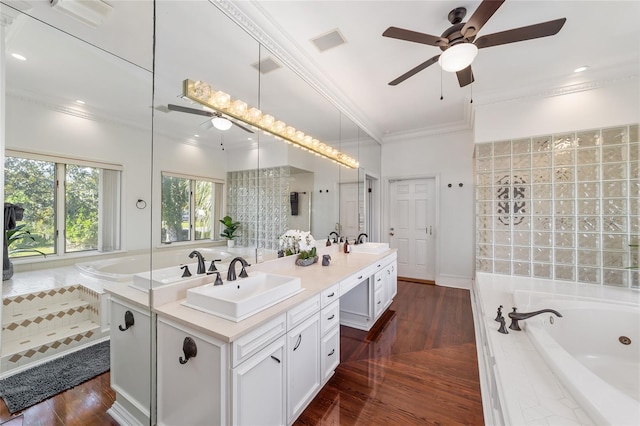 bathroom featuring vanity, tiled bath, wood-type flooring, and ornamental molding