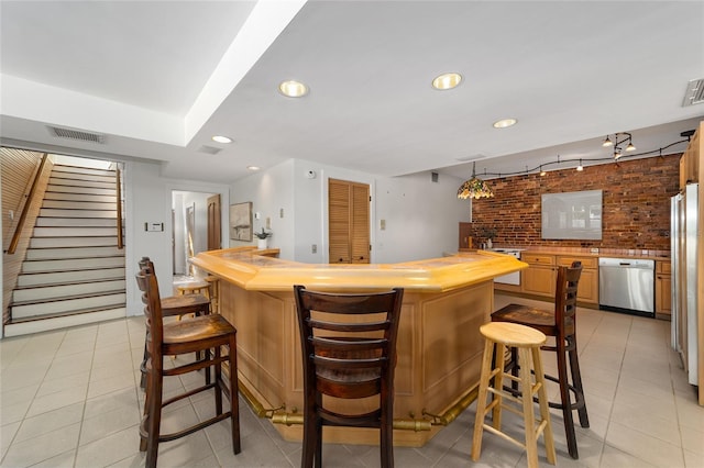 kitchen with wooden counters, dishwasher, a kitchen breakfast bar, and light tile patterned floors