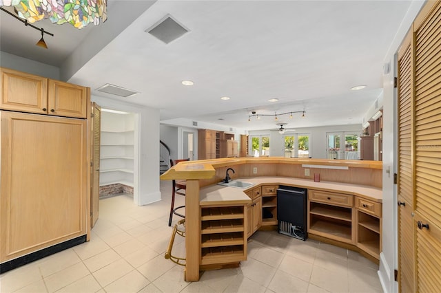 kitchen featuring light tile patterned flooring, a breakfast bar, sink, and kitchen peninsula