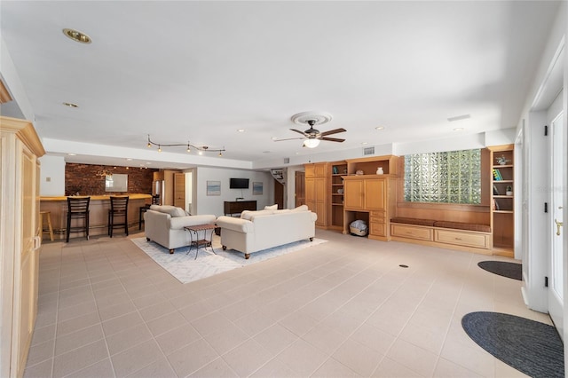 living room with light tile patterned floors, bar area, and ceiling fan