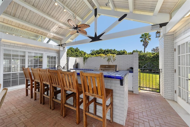 view of patio / terrace featuring grilling area, a bar, and ceiling fan