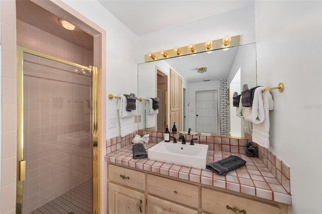 bathroom featuring a shower with door and vanity